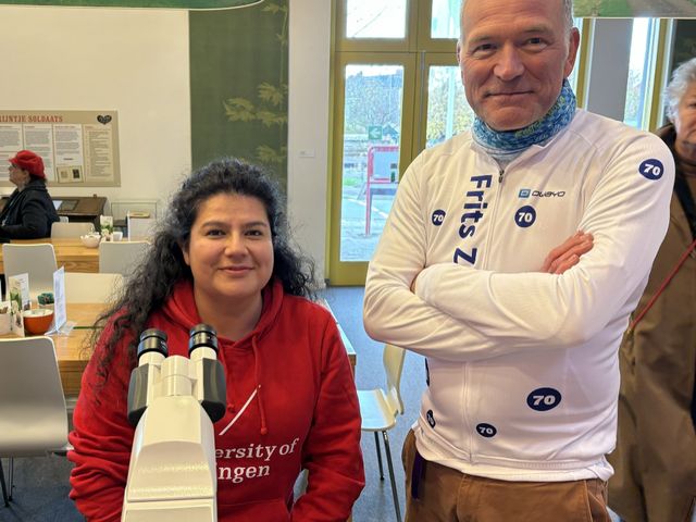 Dr. Carol Garzon Lopez at the 70th anniversary of Zernike's Nobel Prize. Carol assisted in displaying microscope images in the library of a town. The person beside her is Zernike's grandson.