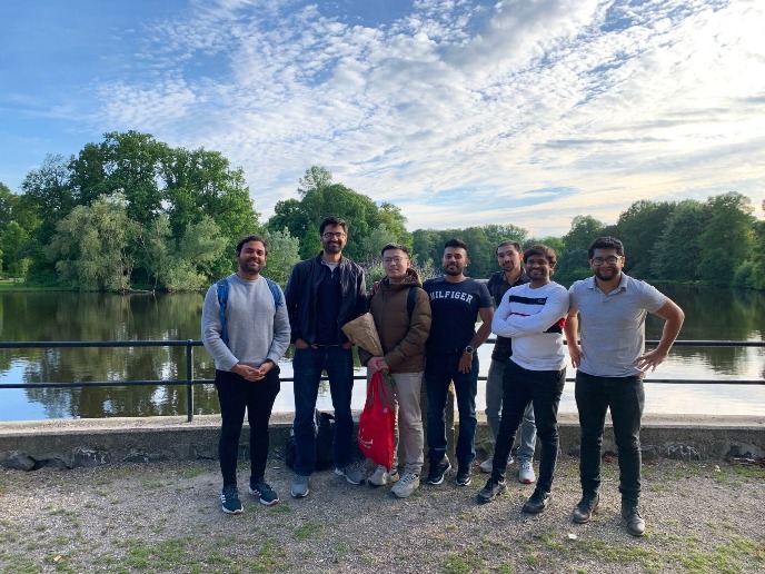 The group is in front of a lake smiling